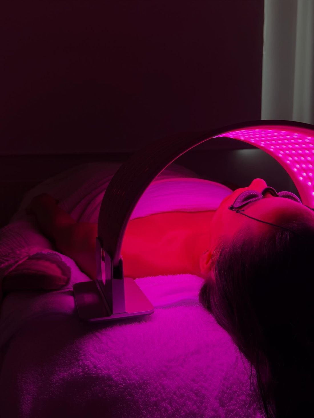 Een klant ligt onder een rode LED-lamp